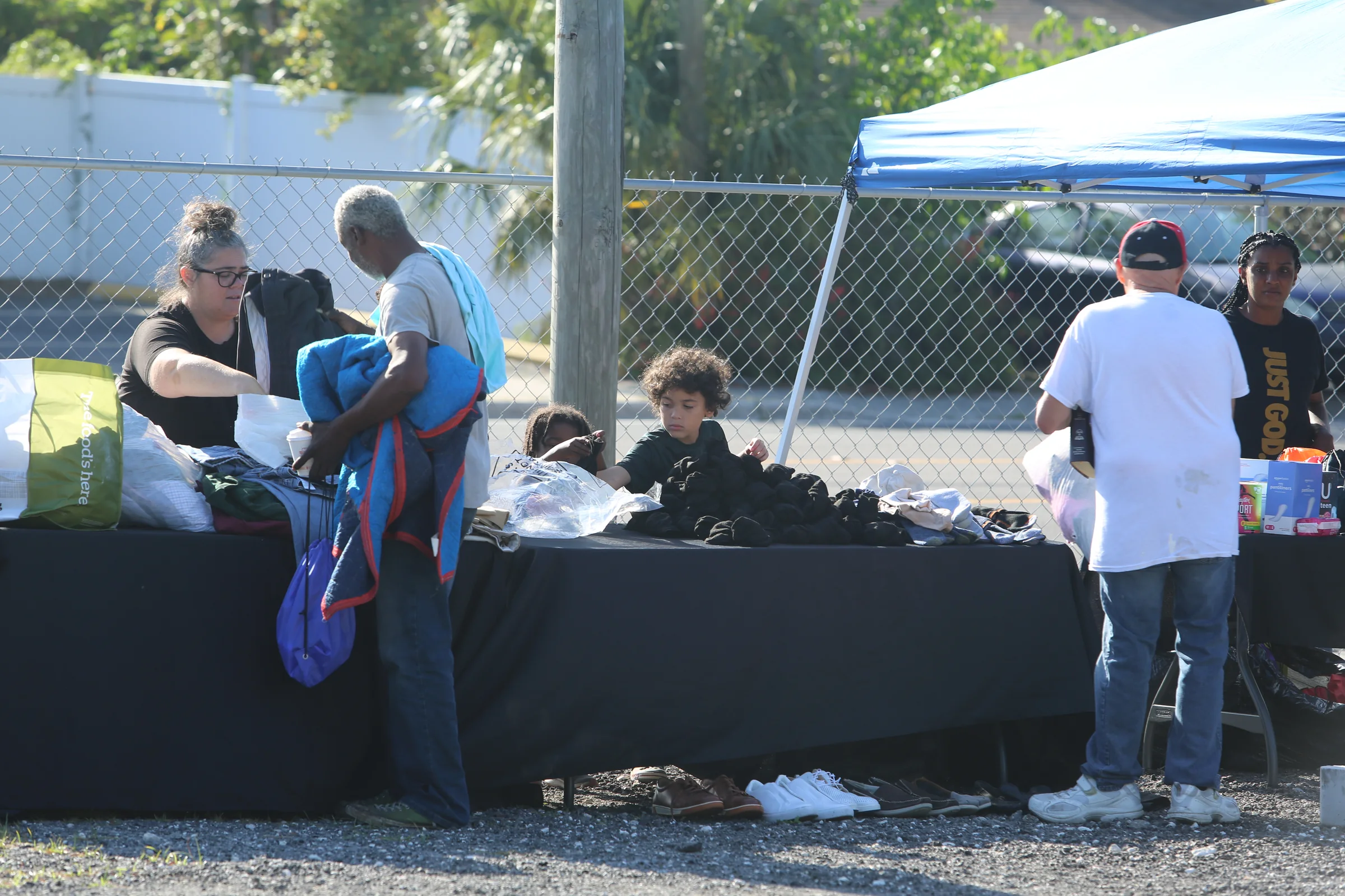 Volunteers helping a neighbor choose clothing and blankets during outreach